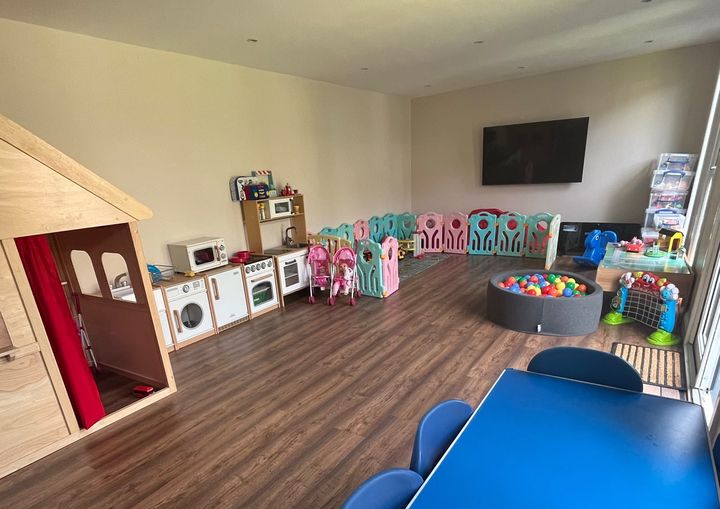 Little Explorers Childminding's playroom, with soft-play fencing, ball pit and TV corner